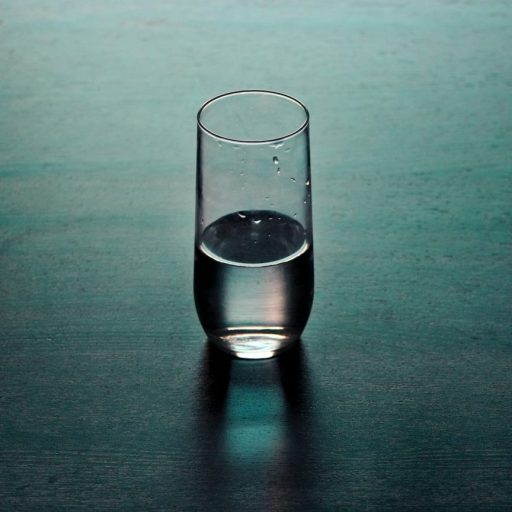 a glass of water sitting on a table.