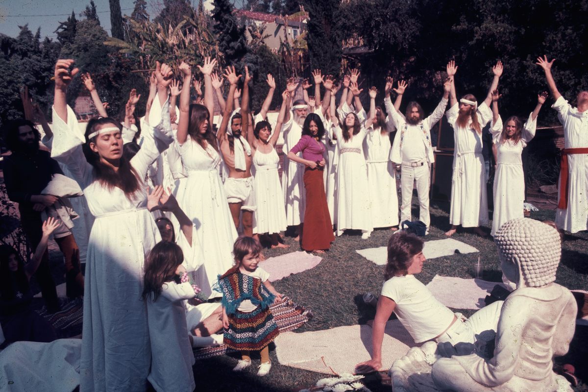 a group of women in white dresses standing around each other.