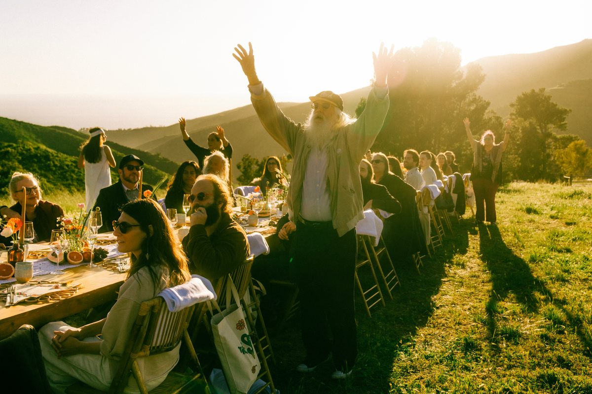 a group of people sitting at a long table.