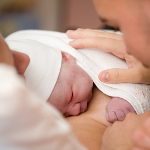 a man and woman holding a newborn baby