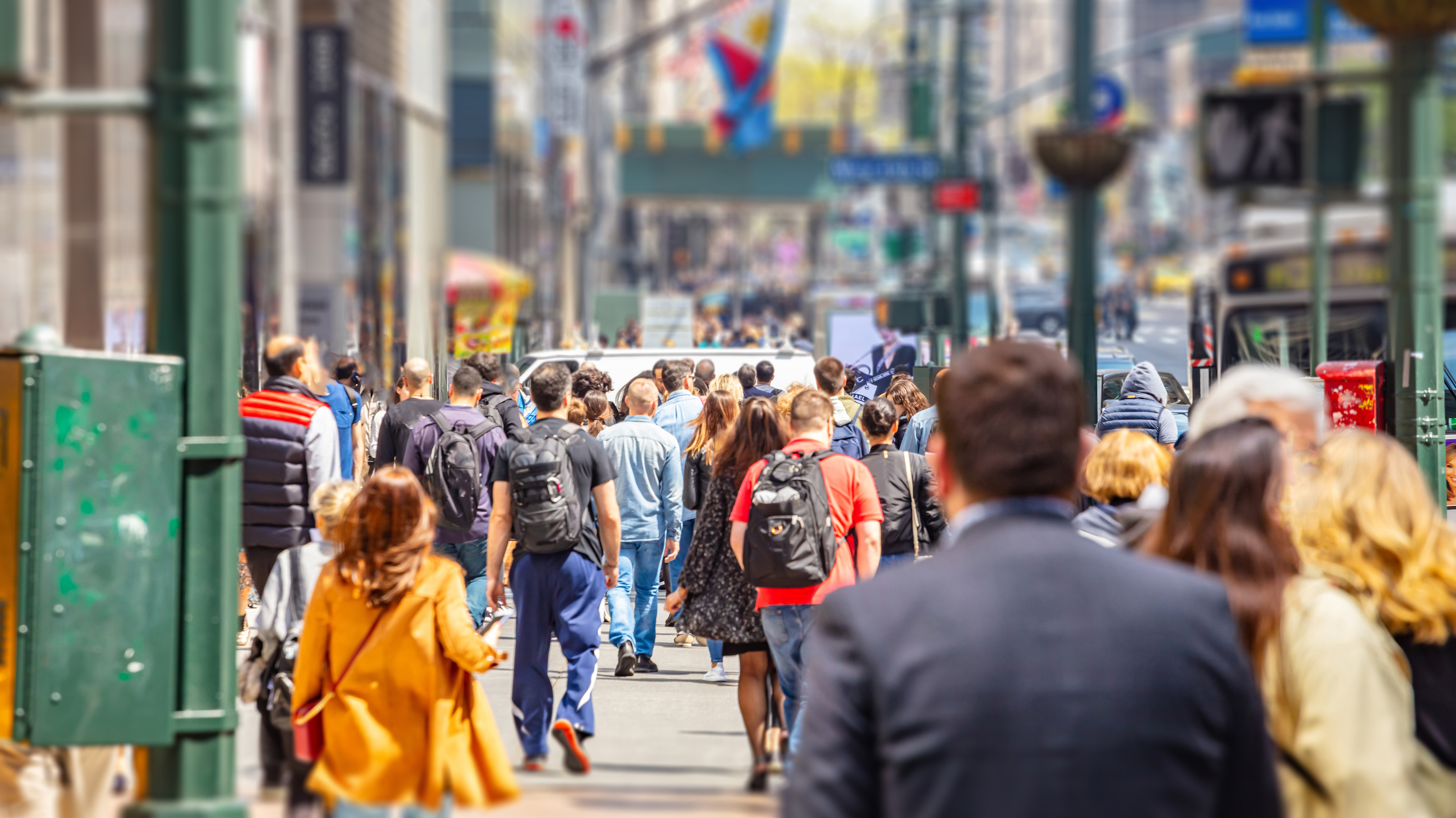 a crowd of people walking down a city street.