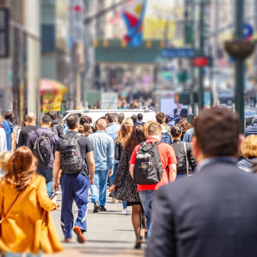 a crowd of people walking down a city street.