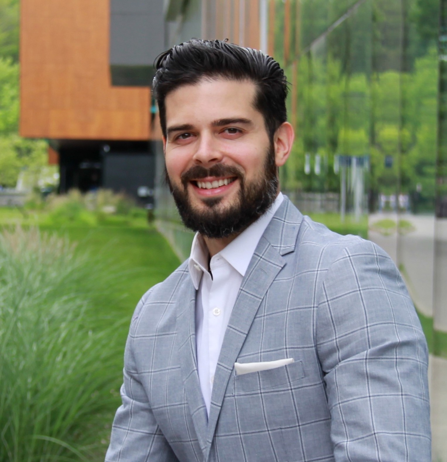 a man with a beard wearing a gray suit.