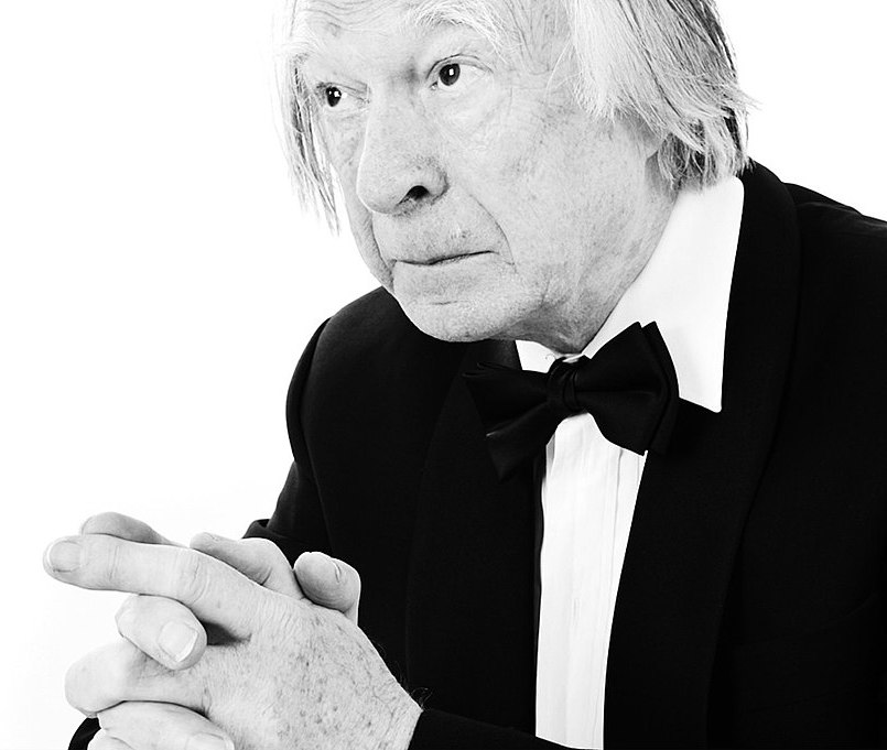 a man in a tuxedo is looking at the camera.