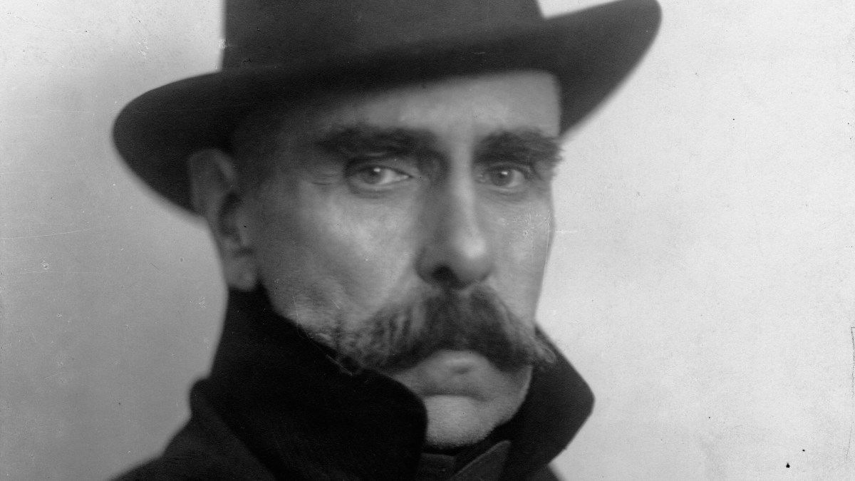 a black and white photo of a man with a mustache.