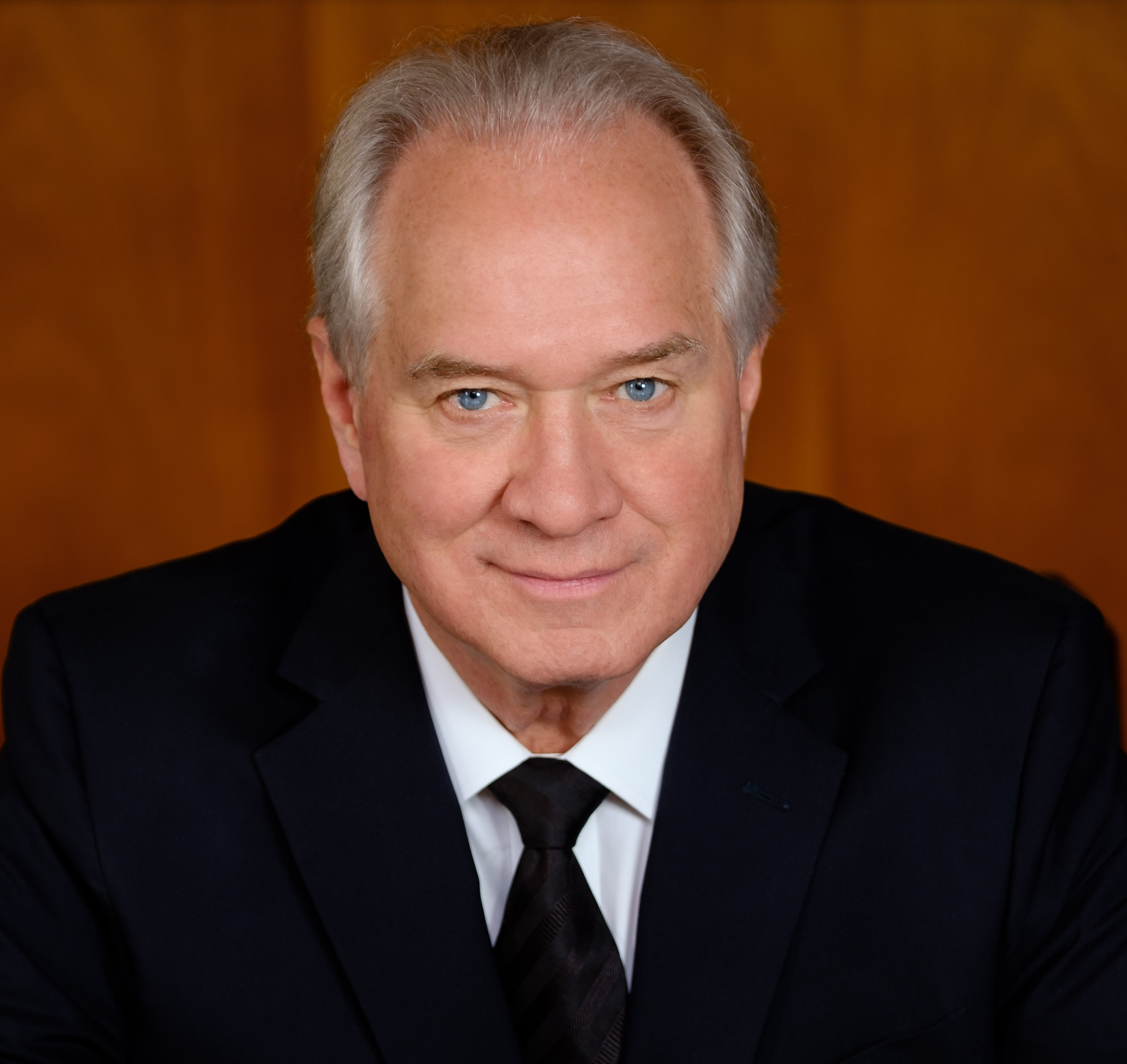 a close up of a person wearing a suit and tie.