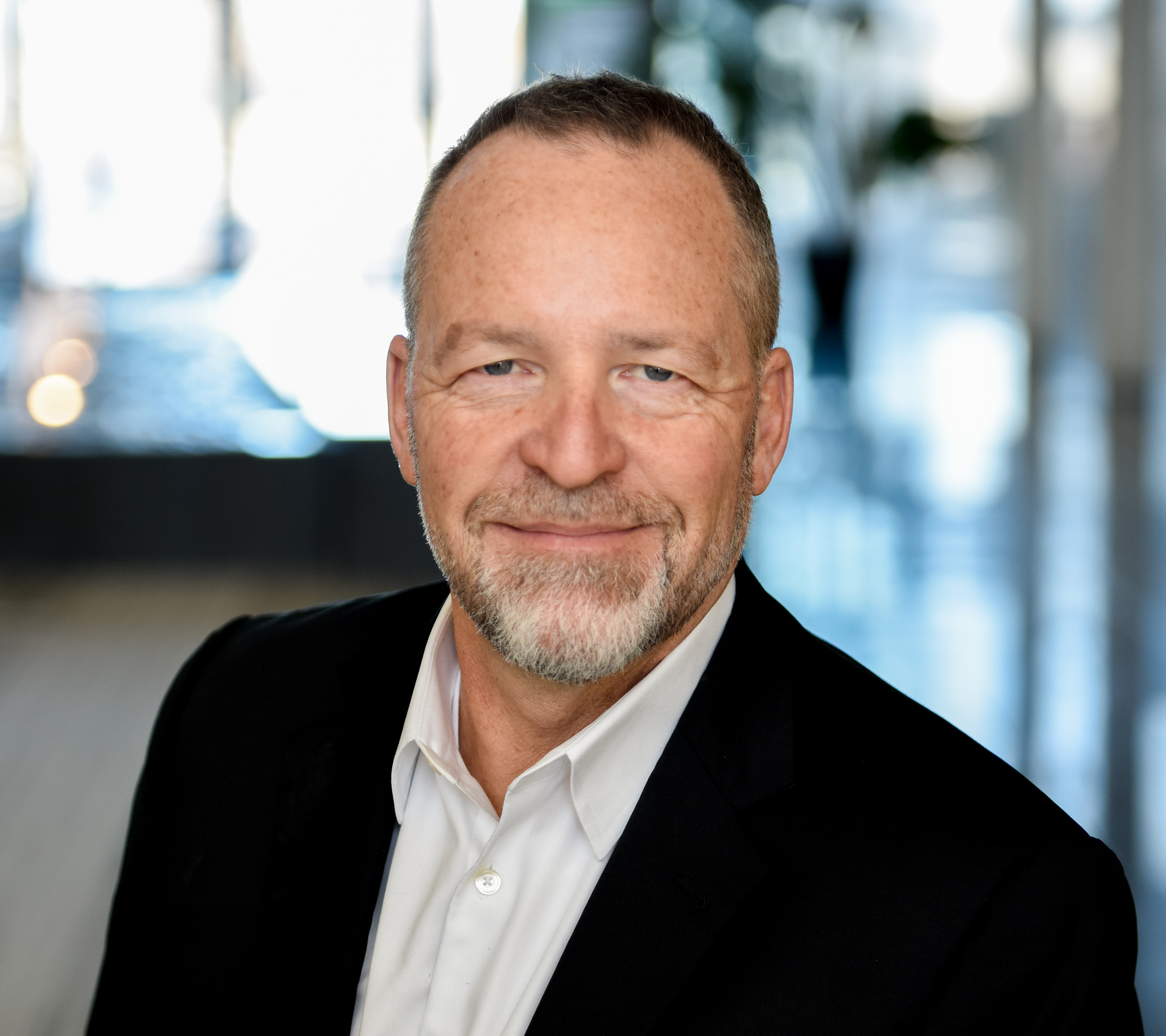 a man in a black jacket and white shirt.