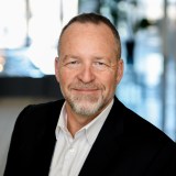 a man in a black jacket and white shirt.