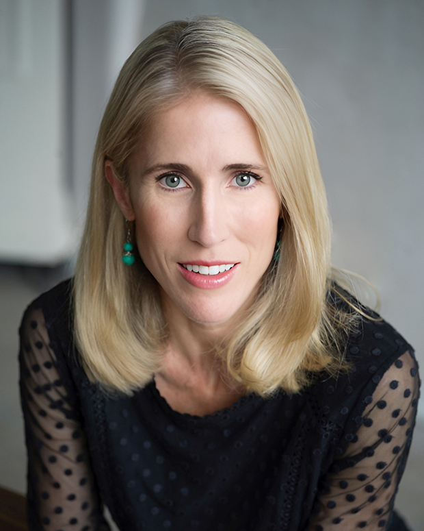 a woman with blonde hair wearing a black top.
