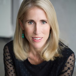 a woman with blonde hair wearing a black top.