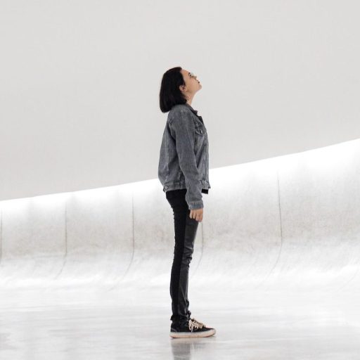 a person standing in a room with a white wall.