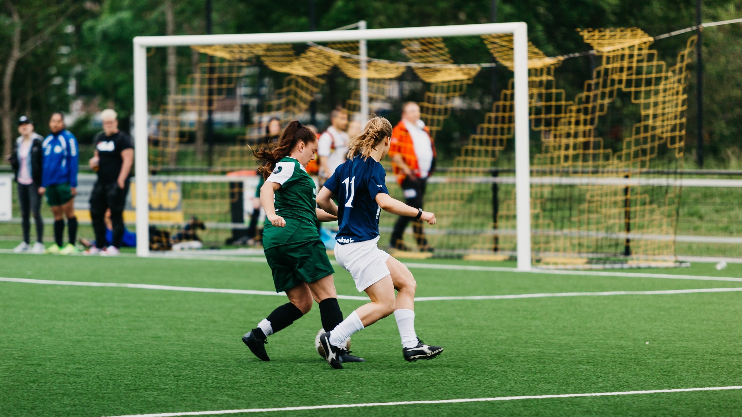 A group of young women playing a game of soccer.