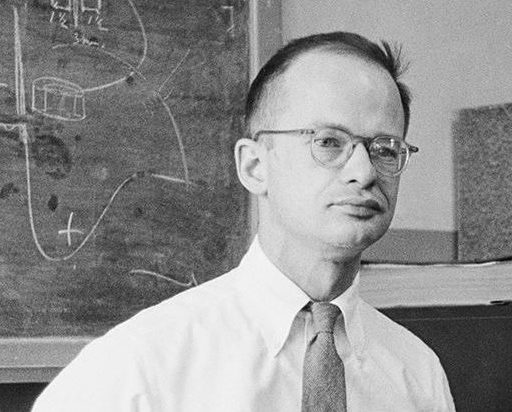 a man standing in front of a blackboard with writing on it.