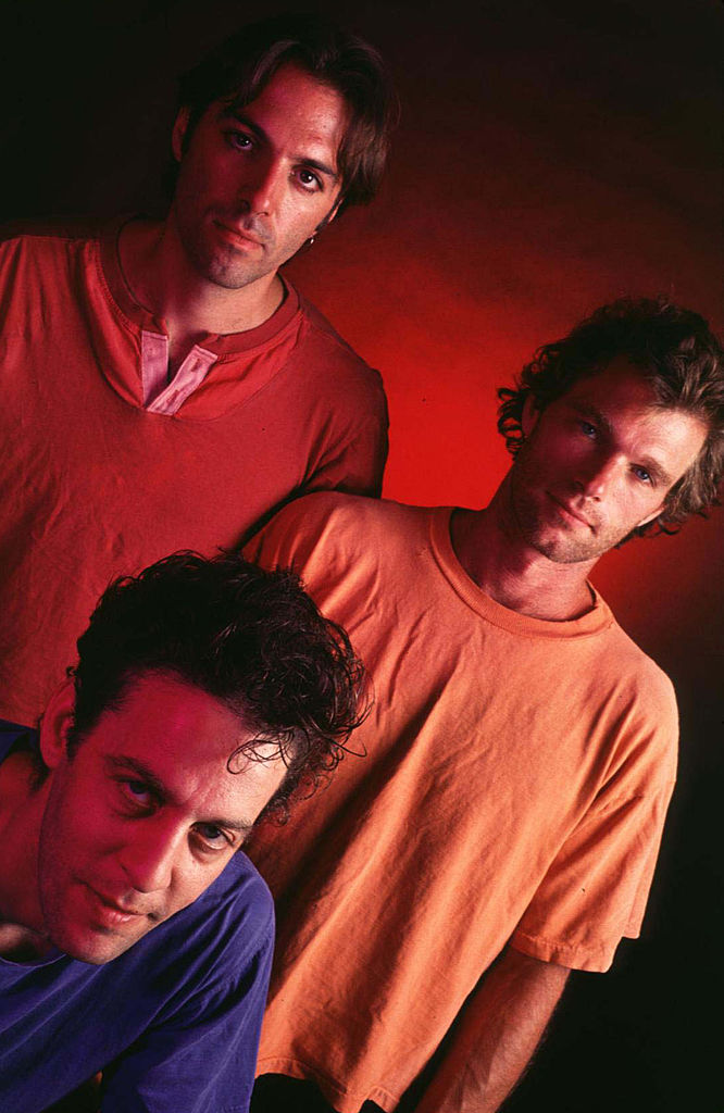 a group of three men standing next to each other.