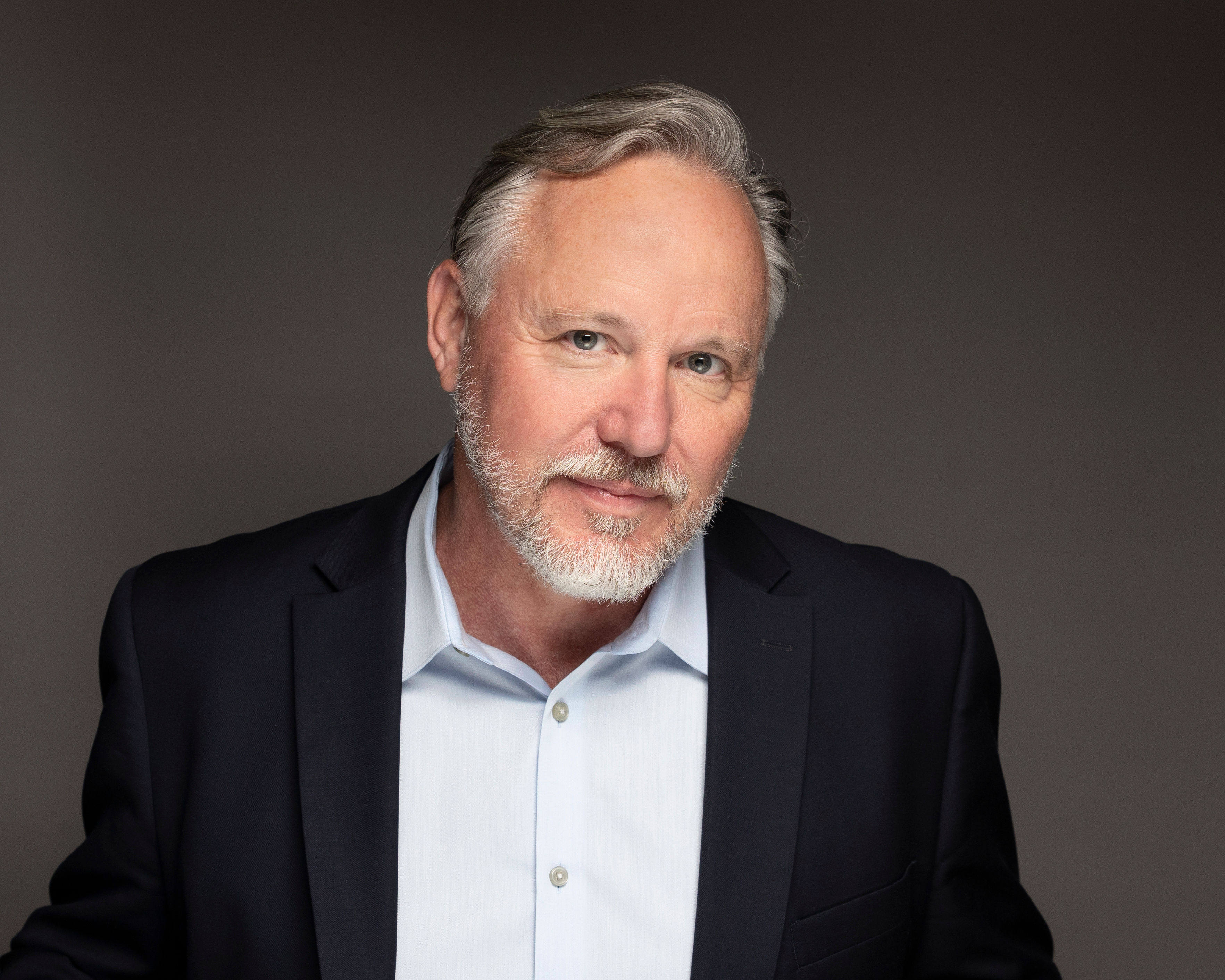 a man with a beard and a blue shirt.
