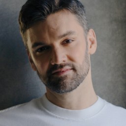 a man with a beard is posing for a photo.