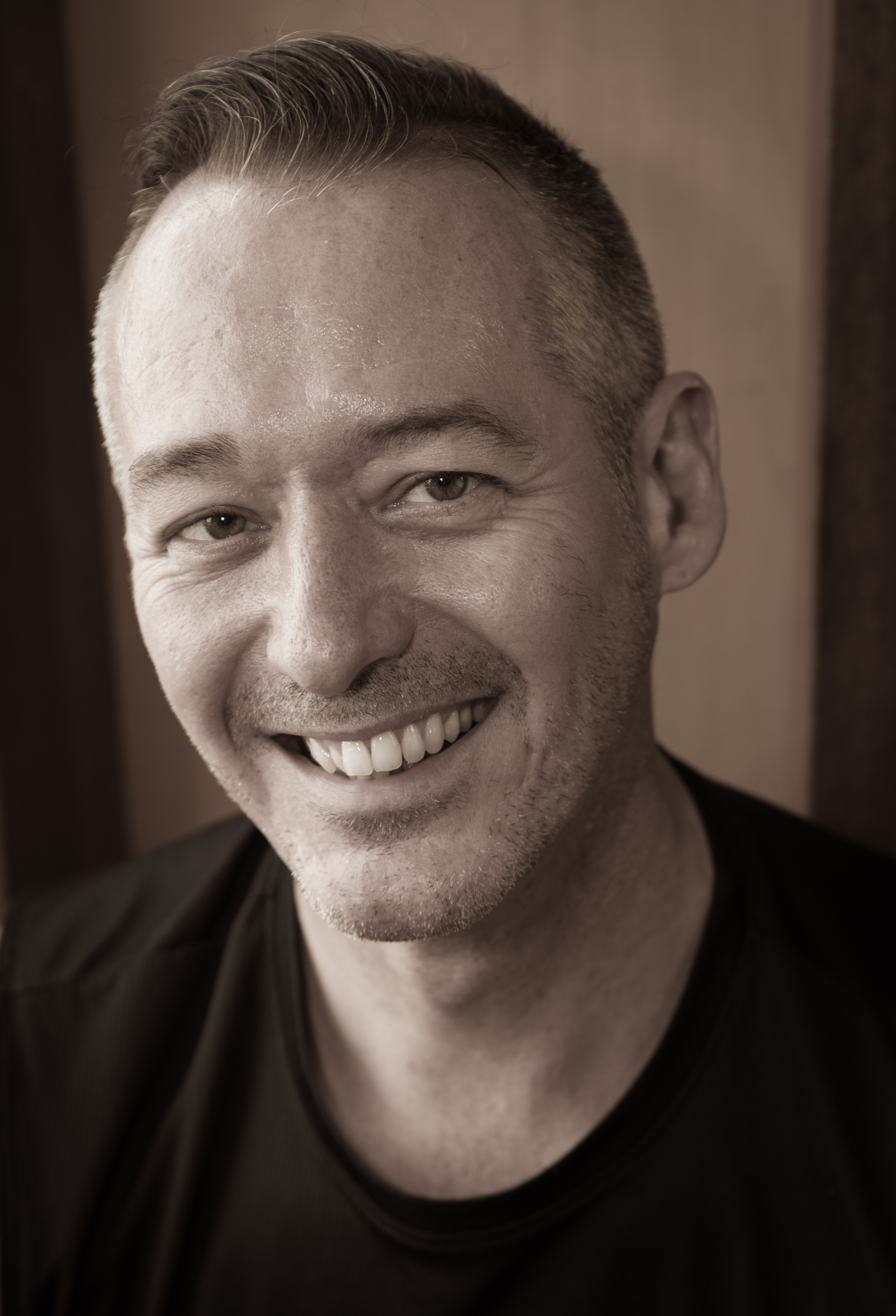 a black and white photo of a man smiling.