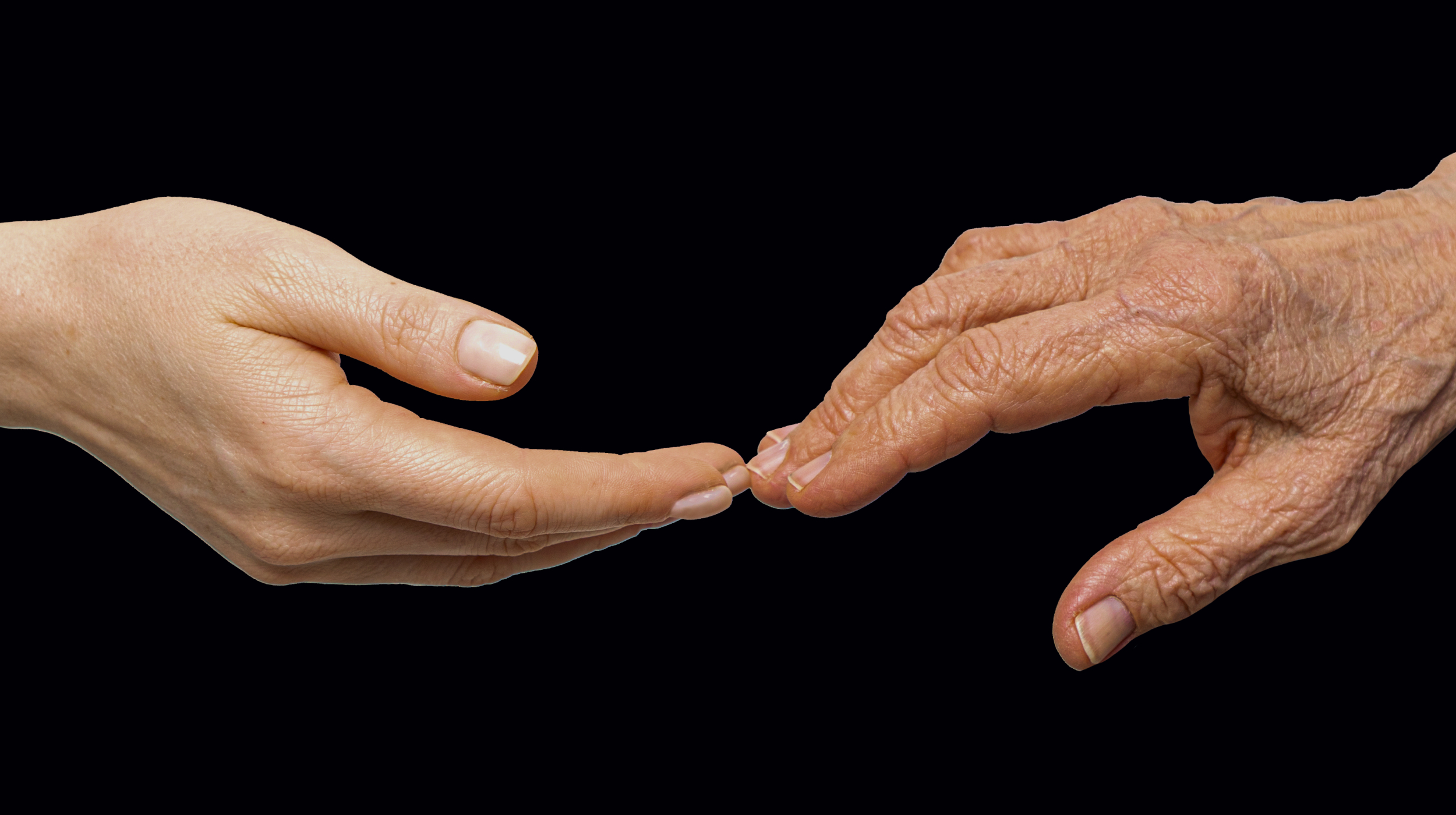 two hands reaching for each other on a black background.