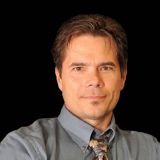 a man in a dress shirt and tie posing for a picture.