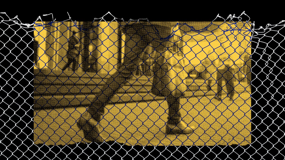 a black and white photo of a person behind a fence.