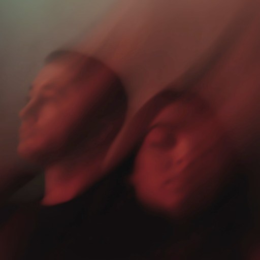 A distorted image of two people in front of a vibrant red background.