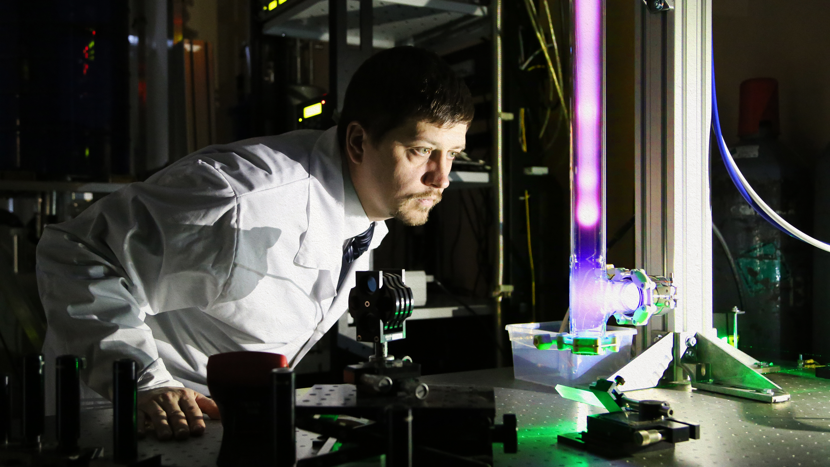 a man in a lab coat looking at a machine.