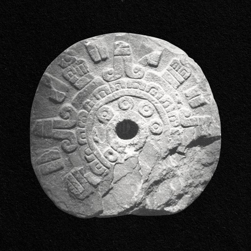 a stone wheel with a hole in it.