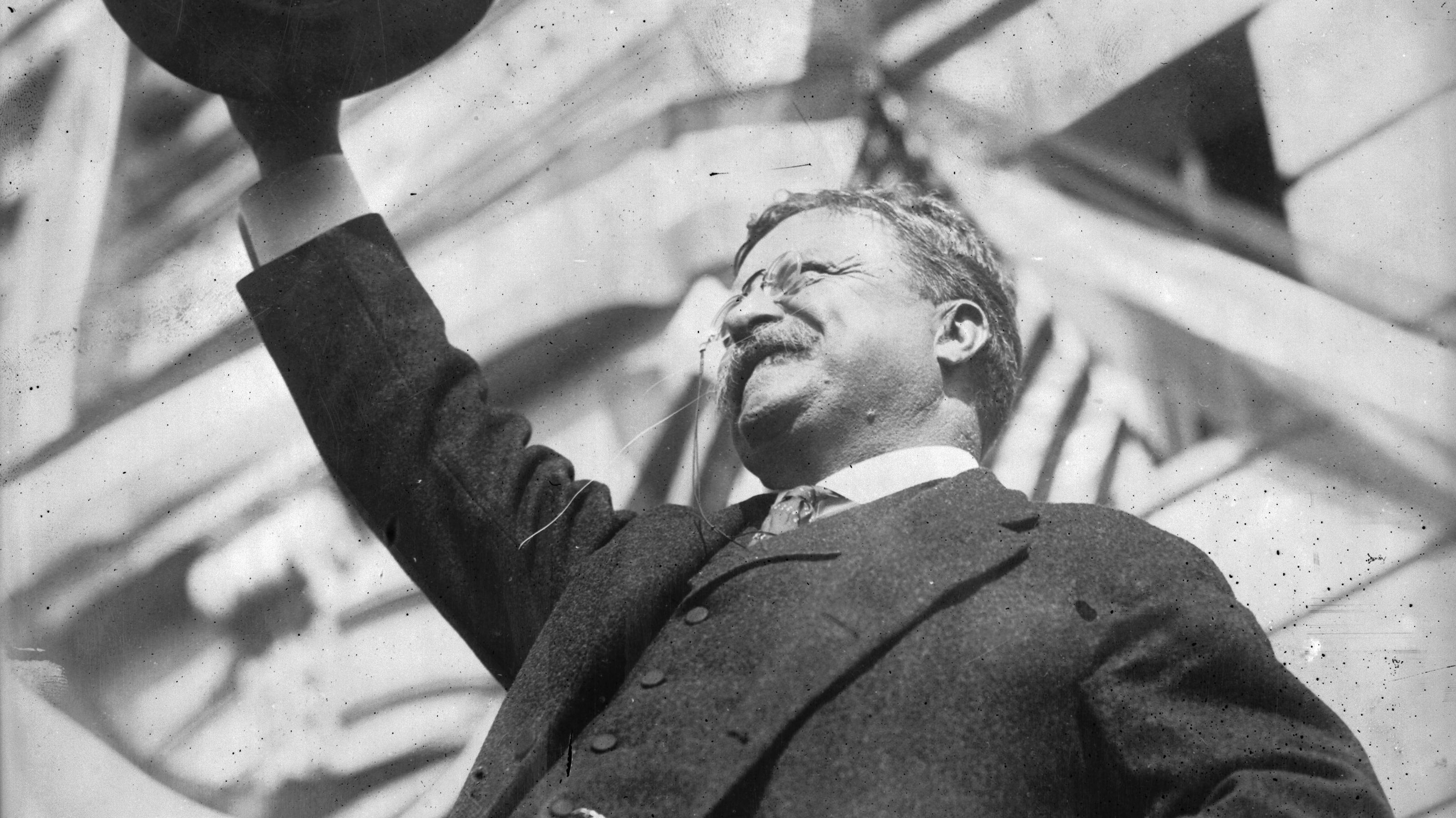 A man in a suit and tie showcasing a hat