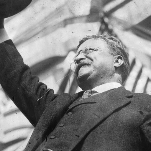 A man in a suit and tie showcasing a hat