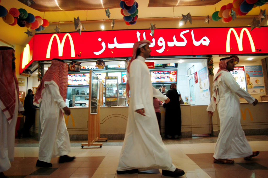 men walking in front of a mcdonald's.