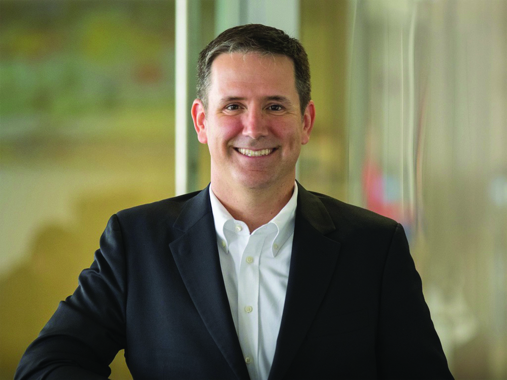 a man smiling in a business suit.