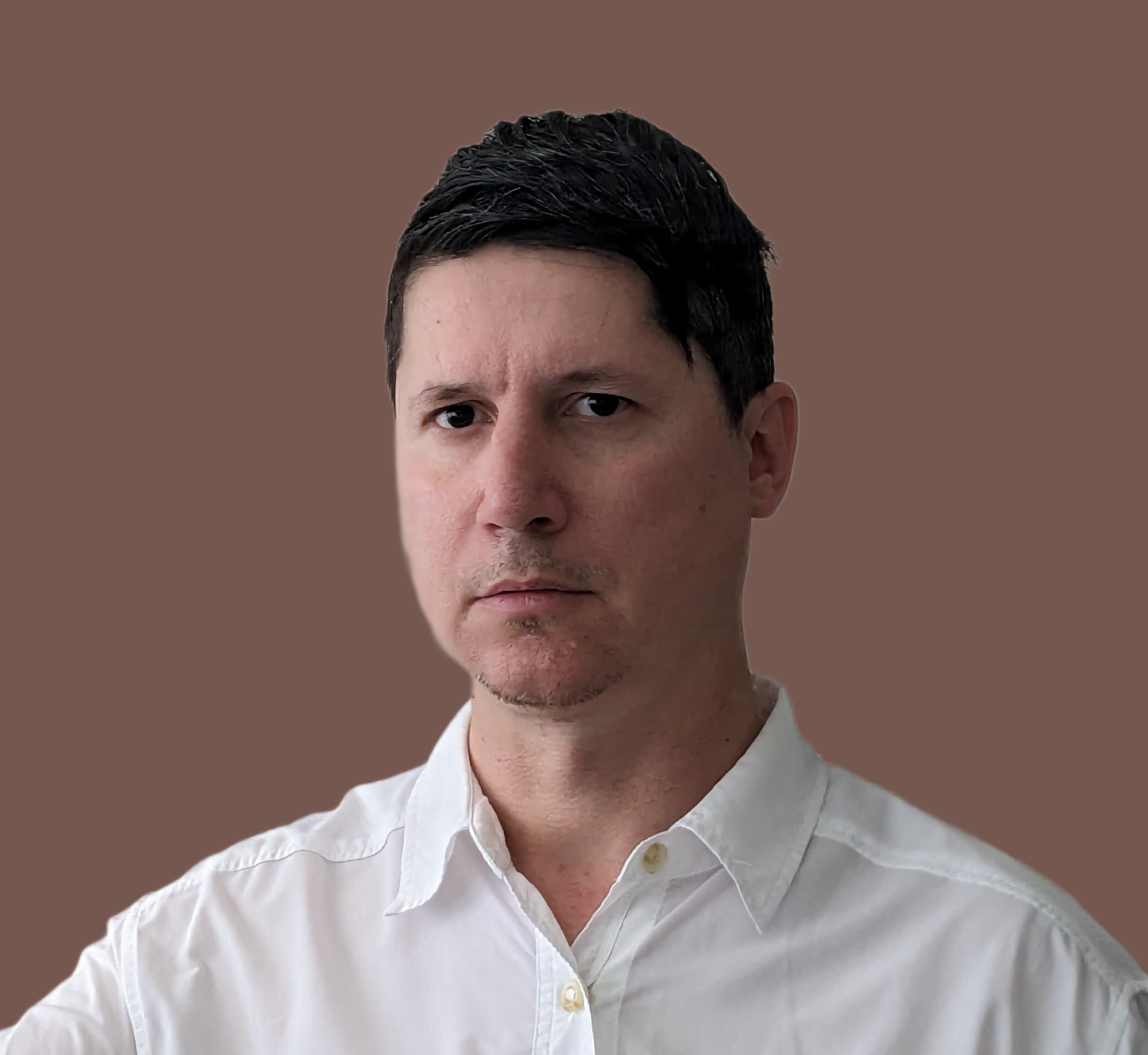 a man in a white shirt is pointing at a brown background.