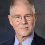 A man in a suit and tie is posing for a photo.