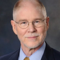 A man in a suit and tie is posing for a photo.
