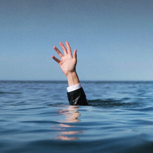 A middle manager's hand emerging from the water.