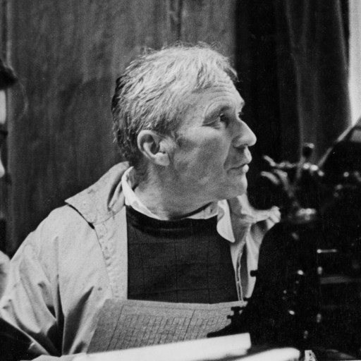 Two men sitting in front of a modern typewriter.