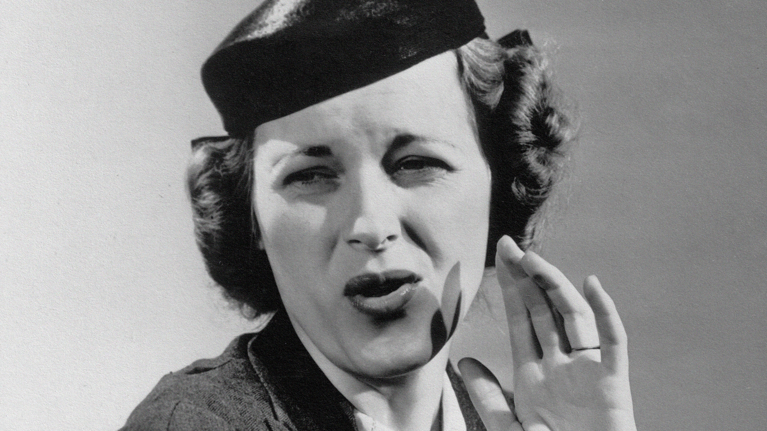 A hat-wearing woman in a black and white photo.
