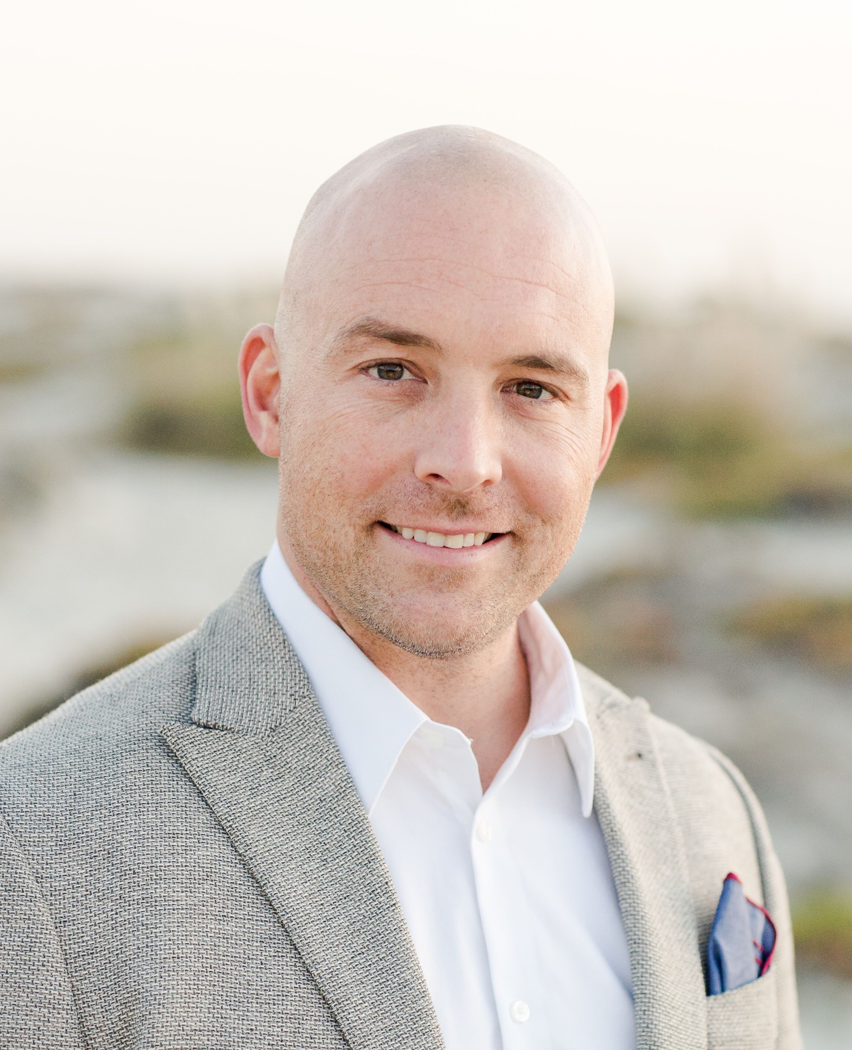A bald man wearing a suit and tie.