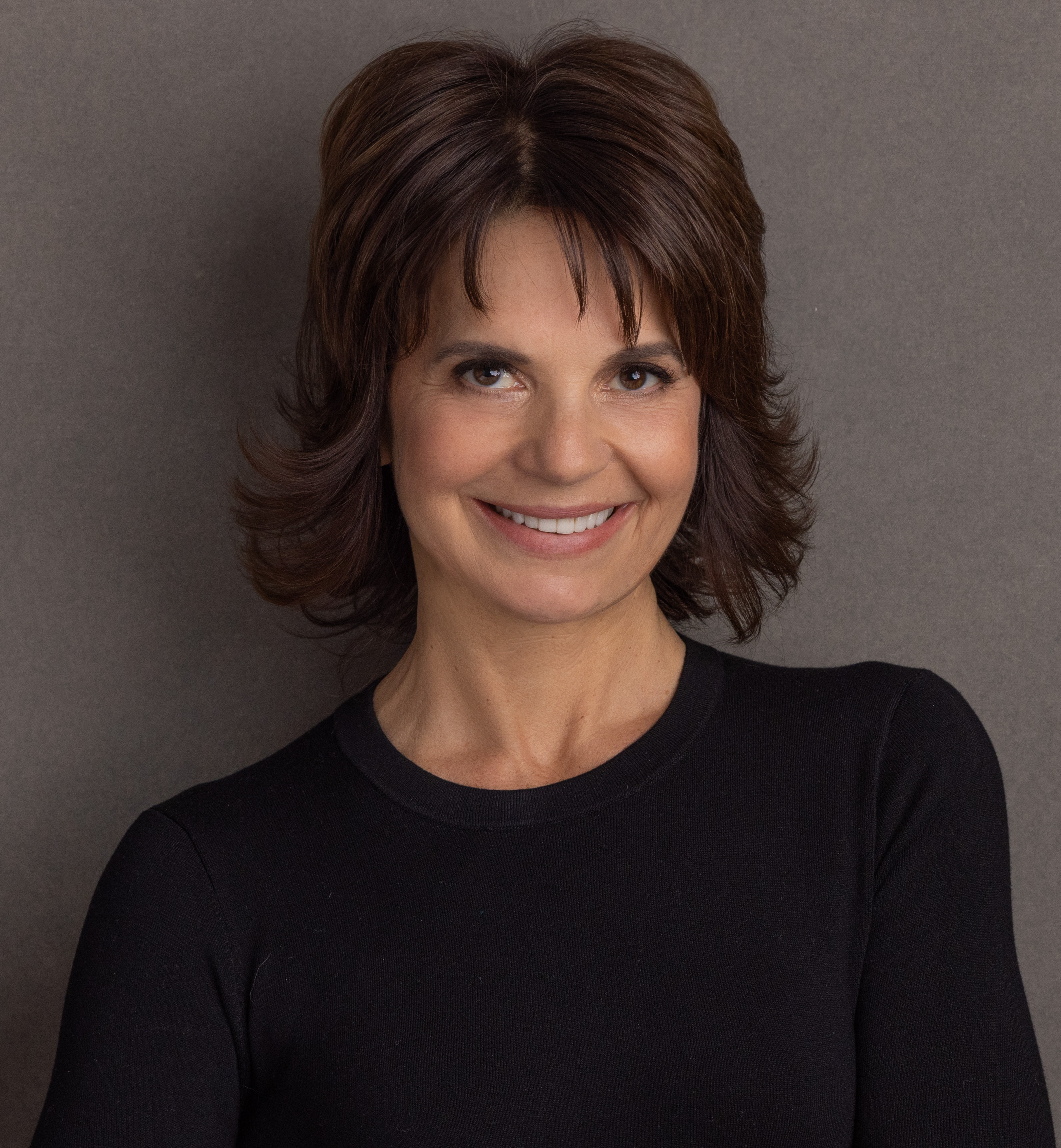 A smiling woman in a black top.