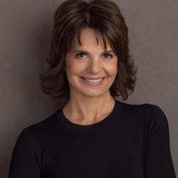 A smiling woman in a black top.