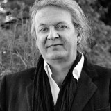 A black and white photo of a man wearing a scarf.