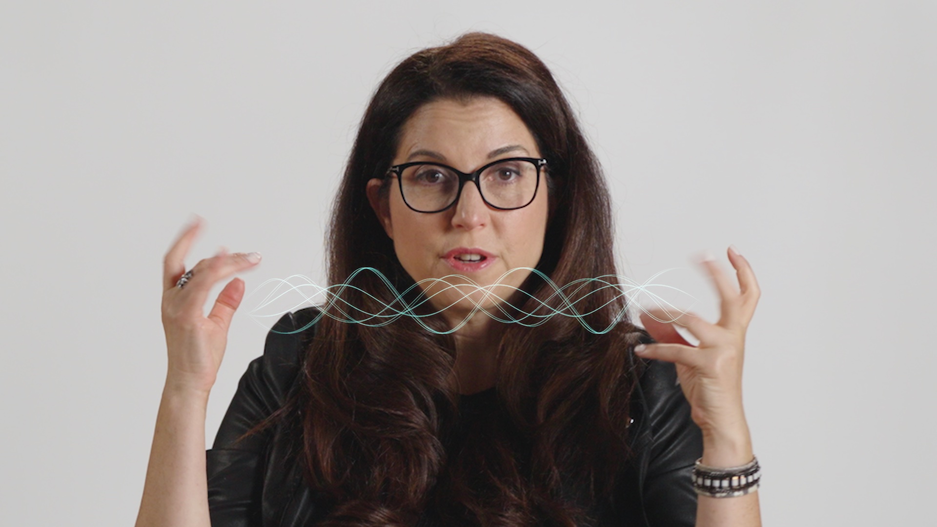 A woman with glasses is making a gesture with her hands.