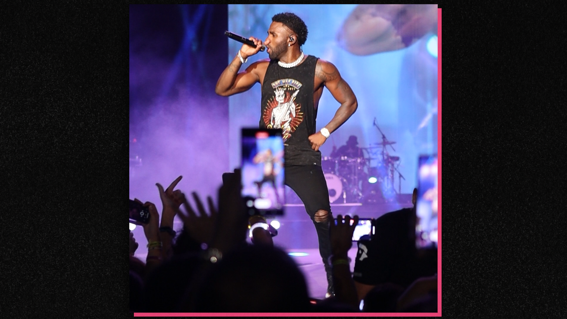 A man is holding a microphone in front of a crowd.