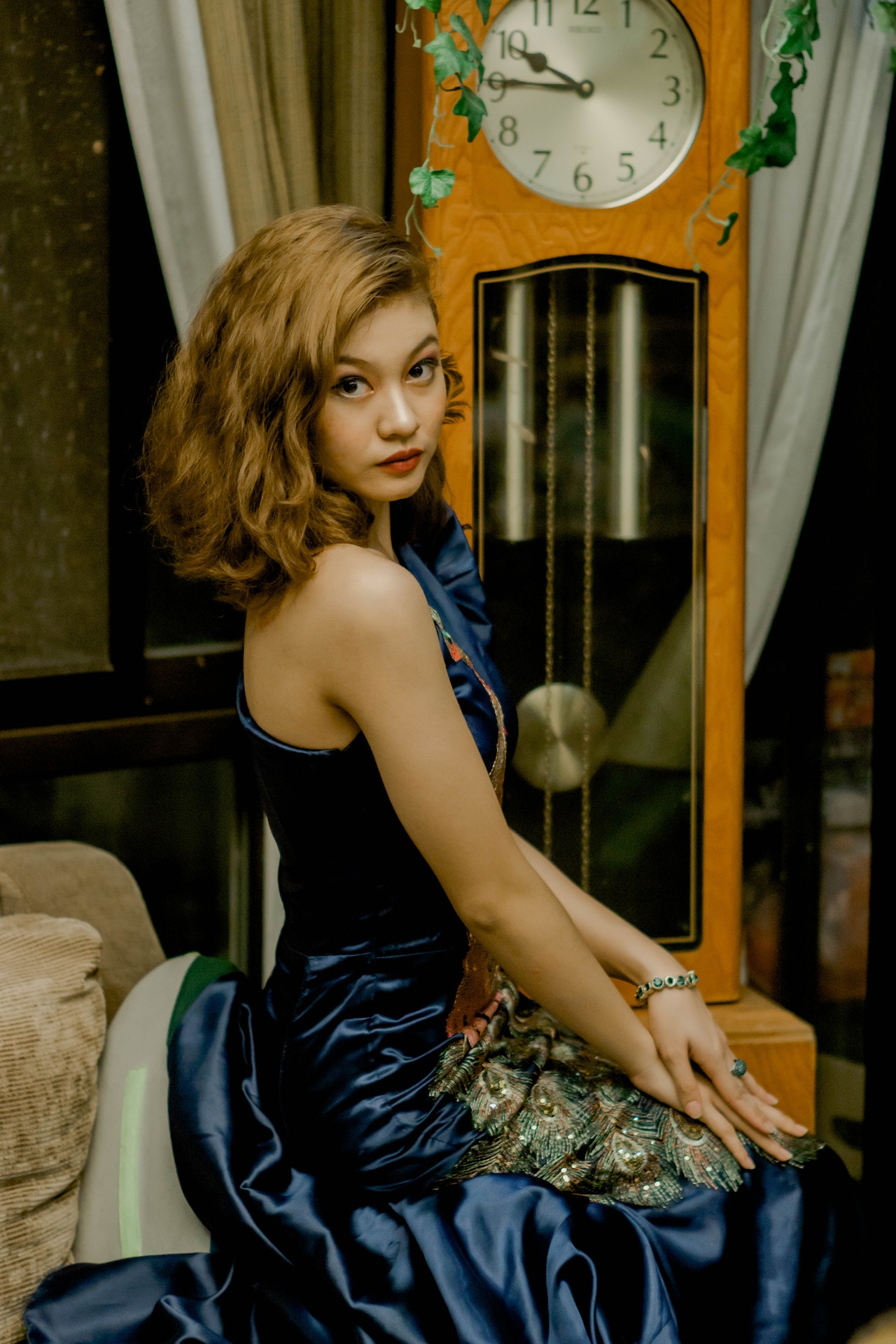 A woman in a blue dress posing in front of America's first clock.