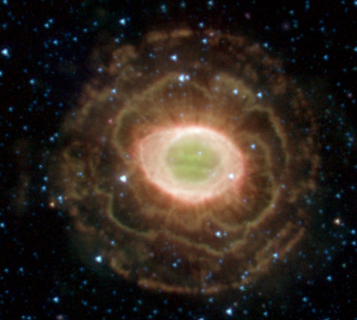 A green nebula in the middle of stars.