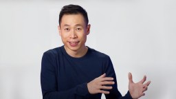 A man in a blue shirt with his hands outstretched.