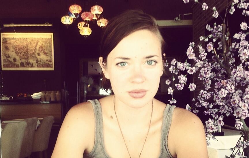 A woman is sitting at a table with flowers.