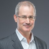 A man in glasses is posing for a photo.