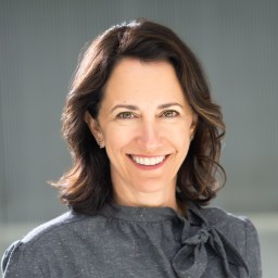 A smiling woman in a gray shirt.