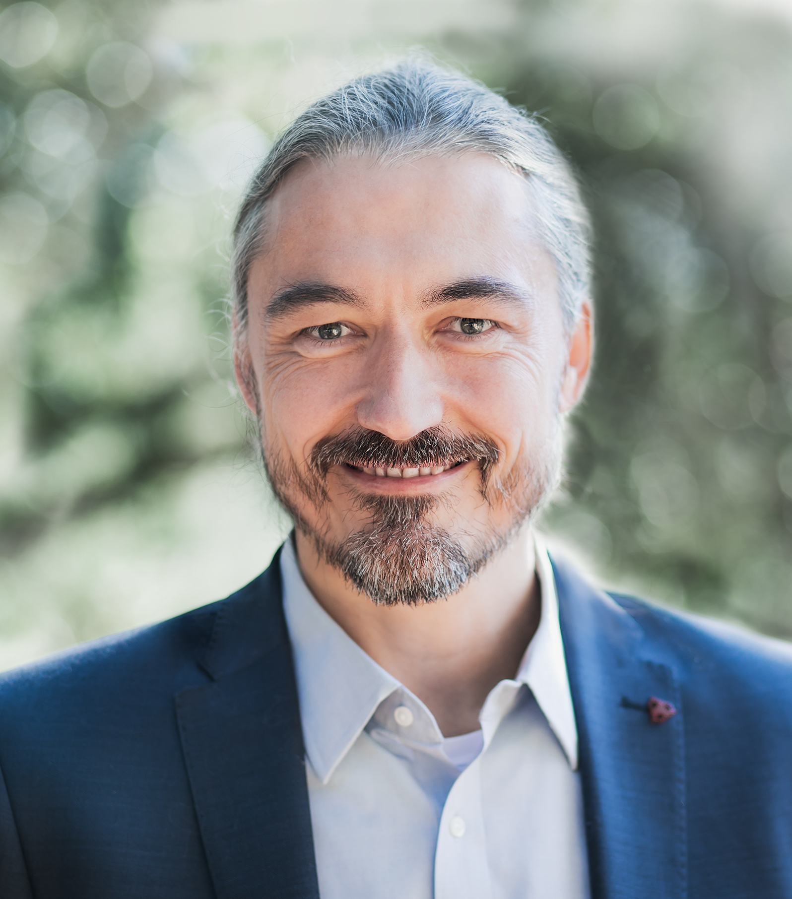 A man in a suit smiles for the camera.